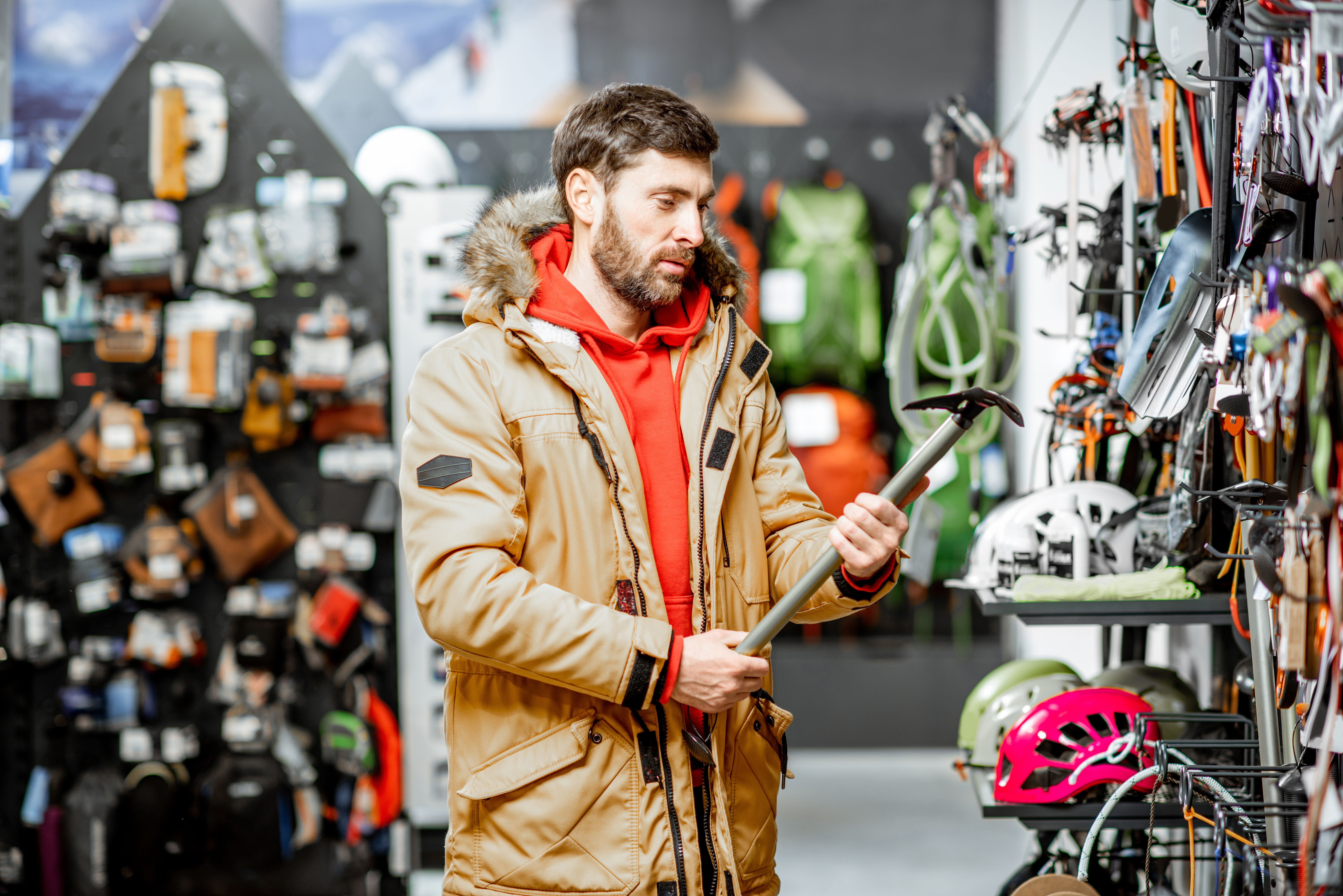 Man choosing choosing mountaineer equipment in the shop